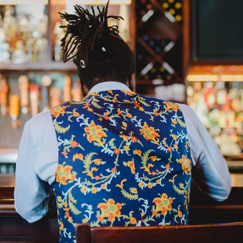 man sitting at a bar wearing a men's vest with a silk back