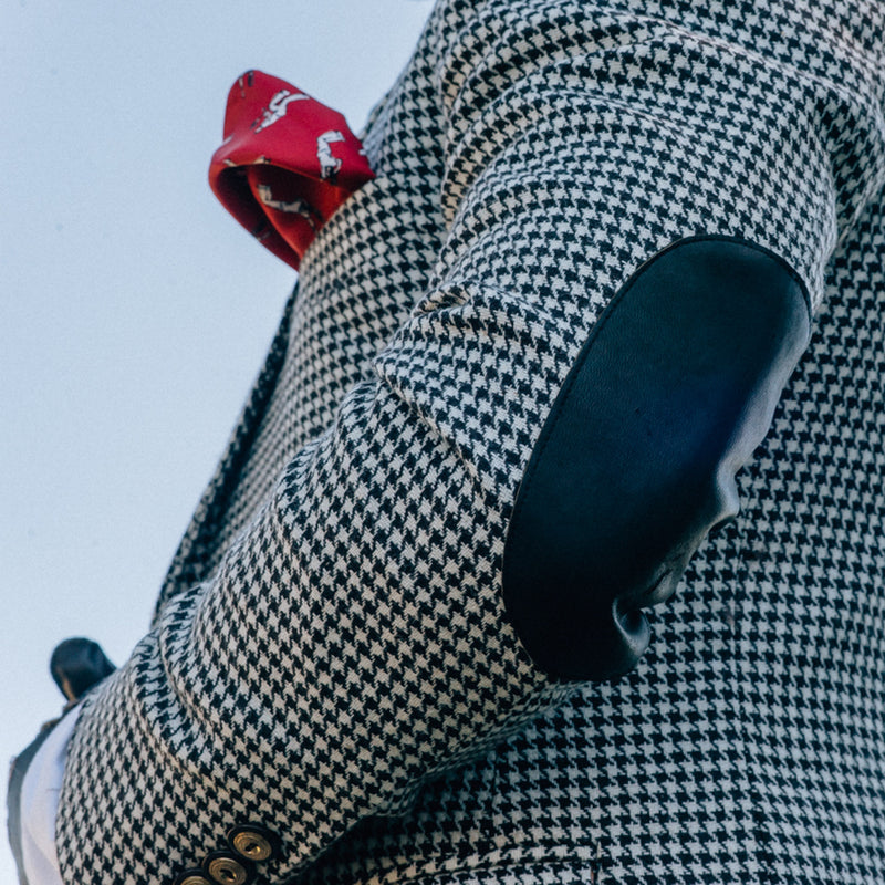 elbow patch on a houndstooth blazer with a red pocket square