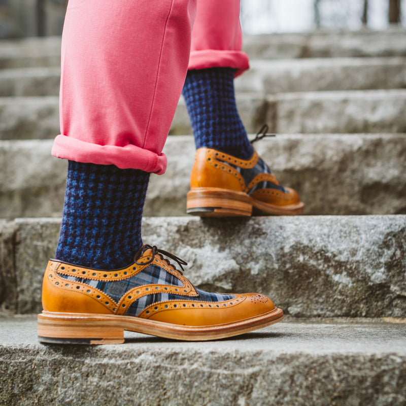 red pant cuffs rolled up showing blue check wool socks underneath